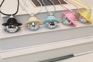 Detailed view of colorful disco ball hat pendants in black, white, blue, pink, and yellow