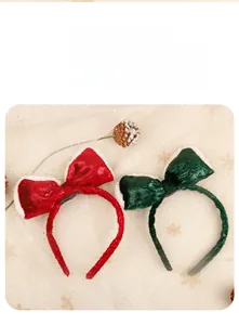Detail of red and green velvet Christmas headbands with white plush trim and pine cones
