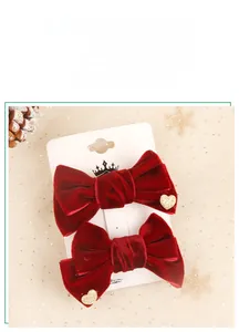 Detail of red velvet Christmas bow clips with gold heart sequins on a display card