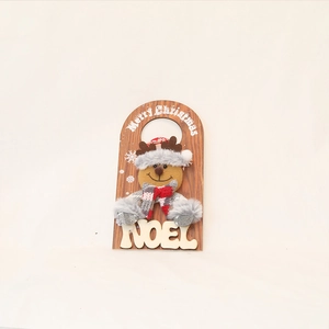 Detail of wooden Christmas door hanger with reindeer plush decor and Merry Christmas text