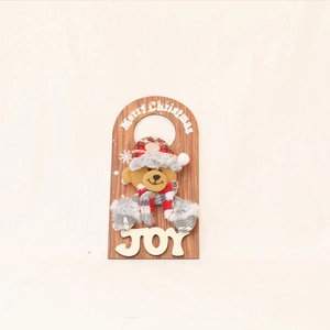 Detail of wooden Christmas door hanger with plush bear and white Merry Christmas text