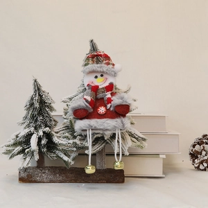 Detailed view of Christmas snowman doll ornament with bells on rustic wooden base