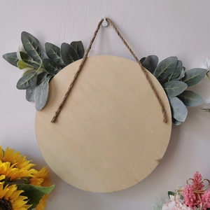 Round wooden gnome sign with rustic artificial greenery and natural jute hanging rope