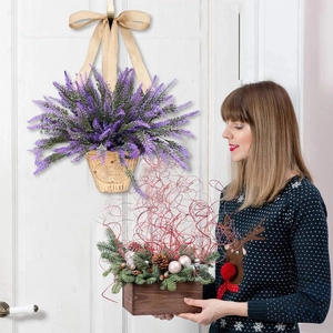 Artificial lavender flower basket with bow hanging on white wooden door for home decor
