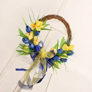 Detailed macro view of yellow and blue tulips wreath with ribbons on a wood easel