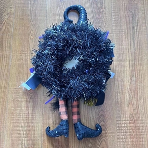 Dettaglio ghirlanda strega di Halloween con cappello di paillettes e gambe lunghe a strisce