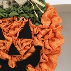 Handmade Halloween burlap pumpkin wreath decoration with black felt face details
