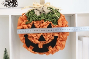 Detailed macro shot showing a 38cm orange burlap Halloween pumpkin hanger with measuring scale