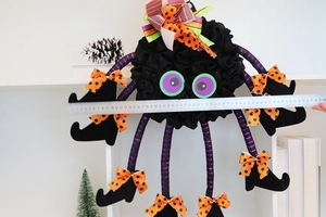 Detailed view of Halloween plush spider prop with purple striped legs and boots measuring 60cm