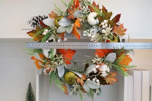 Detail showing the 40cm diameter of an autumn wreath with maple leaves and pumpkins