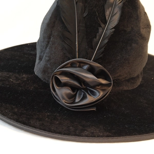 Elegant black velvet witch hat with black feathers and a rose for Halloween costumes