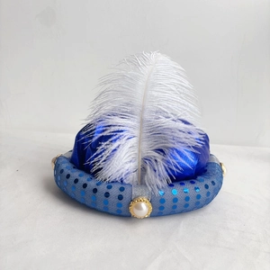 Macro shot of blue Aladdin sultan hat featuring satin fabric with white feather and pearls