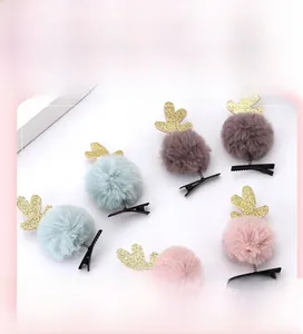 Détail de barrettes de Noël en peluche avec bois scintillants et pompons doux