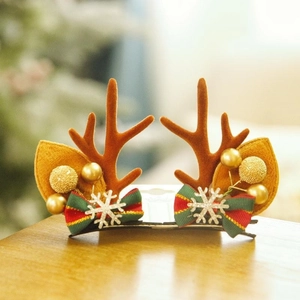 Close-up of reindeer antler hair clips with golden balls and red-green striped bows