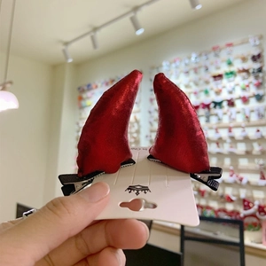 Pair of red metallic devil horn hair clips on display card for Halloween costumes