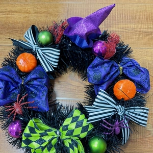 Halloween wreath with purple witch hat, orange pumpkins and glitter spiders for door decor