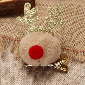 Close-up of reindeer hair clip with brown plush pom-poms and gold glitter antlers