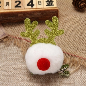 Close-up of reindeer hair clip with white plush pompom and gold glitter antlers