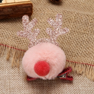Detailed close-up of a Christmas reindeer hair clip with pink pompom and sequined antlers
