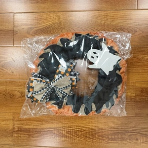 Detail of Halloween ghost wreath featuring orange burlap mesh and a decorative BOO tag