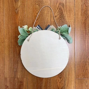 Rustic round wooden welcome sign with faux greenery and striped burlap bow for home decor