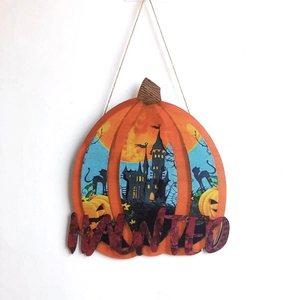 Detail of wooden pumpkin sign with Haunted text and spooky castle print for Halloween