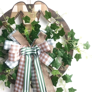 Détail de la couronne de Pâques avec lapin en bois et nœud en toile de jute sur blanc