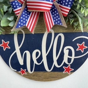 Detailed close-up of Independence Day wooden hello door sign with burlap flag bow