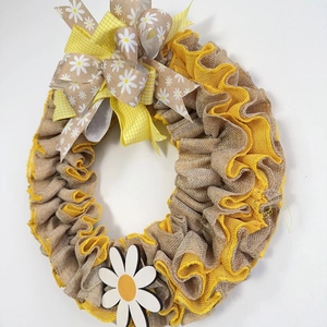 Dettaglio di ghirlanda rustica con margherite, volant in lino e grande fiocco decorativo