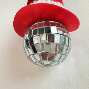Close-up of a festive Christmas disco ball keychain with a red plush Santa hat