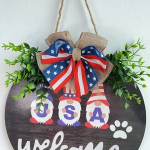 Detail of Independence Day round wooden welcome sign with USA gnomes and burlap bow decoration