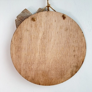 Round wooden Independence Day welcome sign with burlap bow and natural wood grain texture