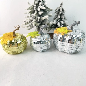 Close-up of glass disco mirror pumpkins in gold and silver for festive party decoration