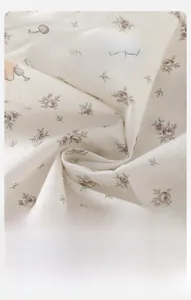 Gros plan sur tissu floral pour bébé montrant la texture douce et respirante