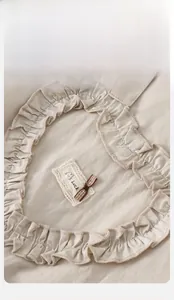 Détail d'un ensemble beige pour bébé avec écusson cœur à volants et broderie chiot
