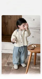 Detail view of baby boy hooded jacket with puppy embroidery and casual denim pants