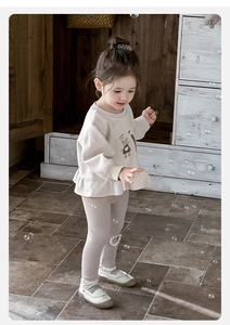 Detailed view of beige ruffled hem sweatshirt with Happy Cat print and lace legging