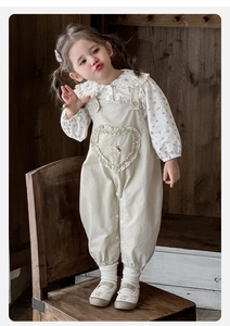 Détail d'une chemise florale avec col Peter Pan en dentelle et poche volantée en cœur