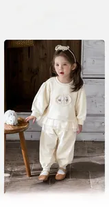 Détail du sweat beige pour bébé fille avec broderie dentelle et ourlet en tulle