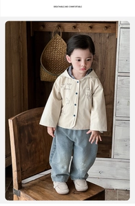 Detail of baby boy beige hooded jacket with puppy graphic and light blue denim harem pants