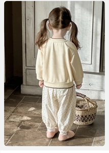 Detail of yellow toddler sweatshirt and polka dot pants with high-quality cotton texture