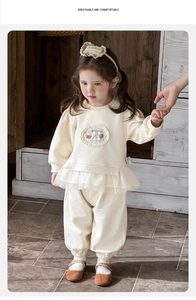 Détail d'un ensemble en maille gaufrée crème pour bébé fille avec dentelle et finitions en tulle