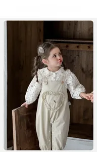 Détail du chemisier à fleurs pour bébé fille avec col dentelle et pantalon à bretelles