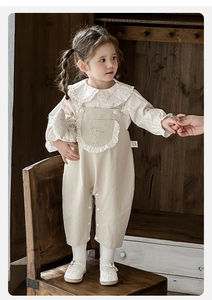 Détail d'une tenue deux pièces pour fille avec chemise à col en dentelle et salopette lapin