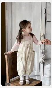 Détail de la salopette florale pour bébé fille avec broderie cœur et haut à manches roses