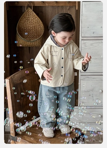 Detail of baby boy hooded jacket with blue plaid lining and casual denim pants set