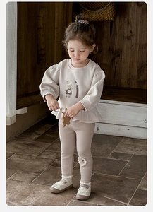 Detailed view of girls cotton set featuring happy cat print sweatshirt and ruffled hem