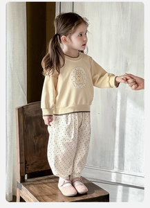 Detail of baby girl cotton outfit featuring yellow sweatshirt with rabbit embroidery