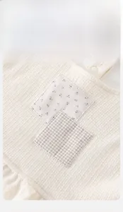 Détail du sweat pour bébé fille avec écussons floraux et texture en maille gaufrée