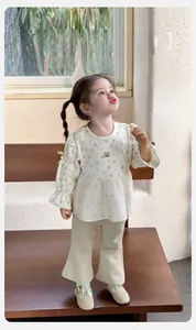 Detailed macro view of infant floral cotton blouse with ruffles and flared pants